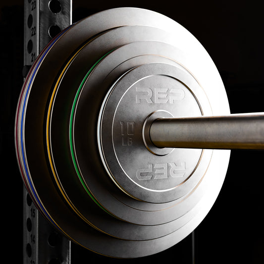 REP Fitness Calibrated Steel Plates in LB loaded onto a barbell on a PR-5000 rack